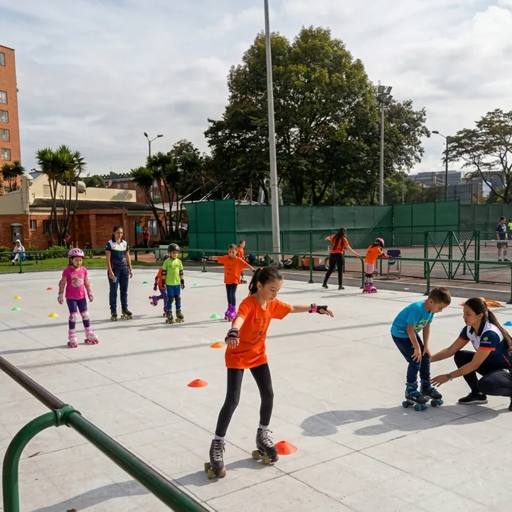 Niños con patines y protecciones practican en una pista al aire libre.